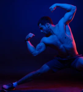 A man is flexing his muscles in front of a blue background